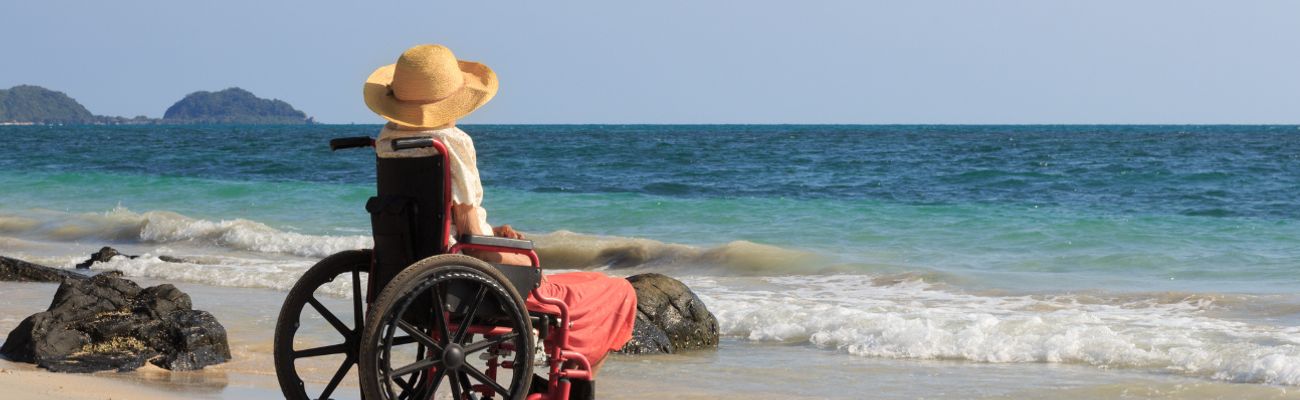 Vrouw in een rolstoel op het strand